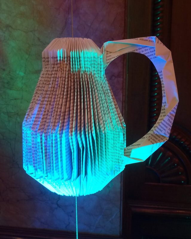 Jug is created with paper folding art from scrap books.